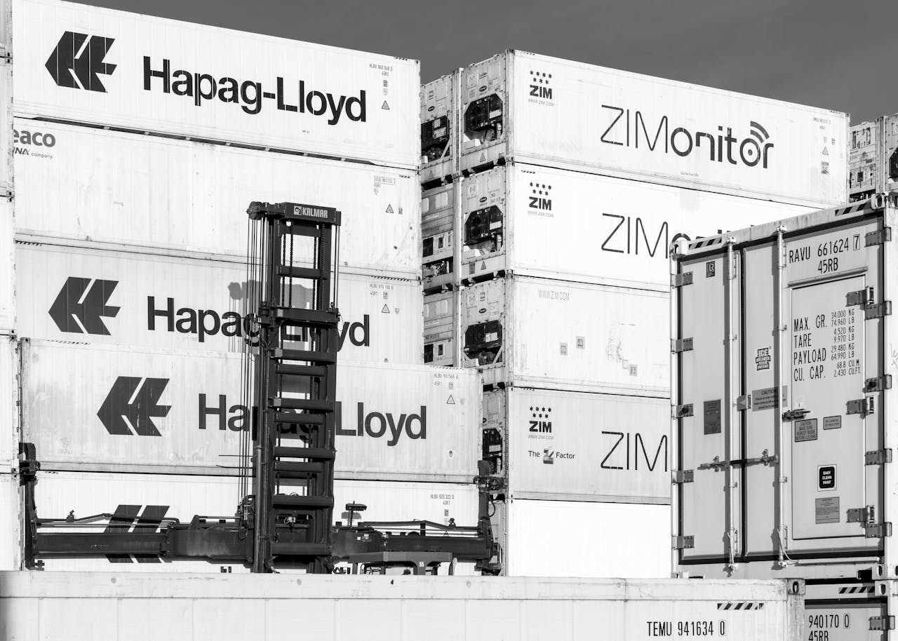 Black and white image of stacked shipping containers in Hamburg, showcasing logistics and trade.